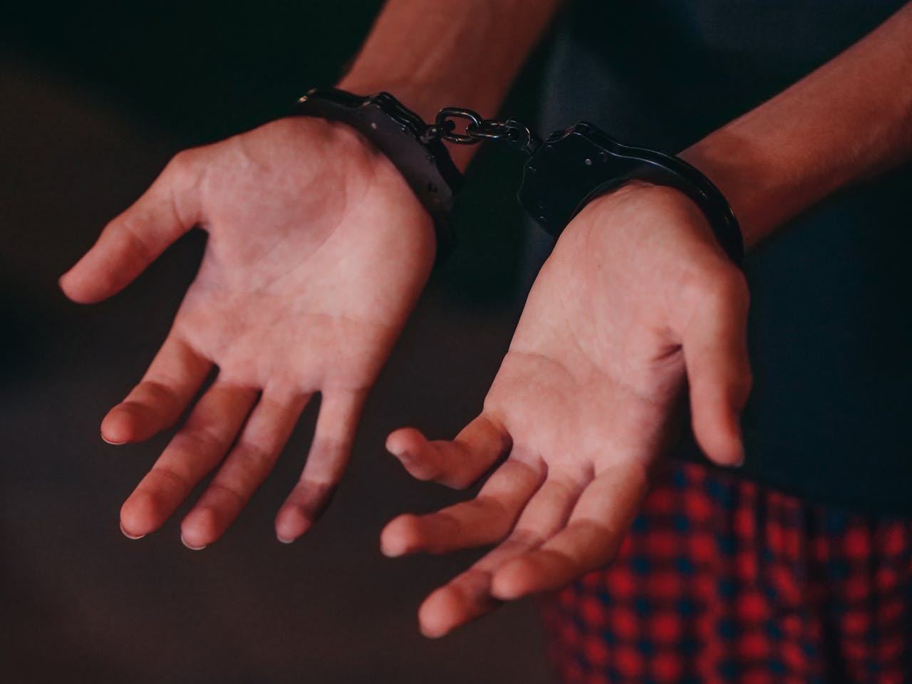 Services-02 A close-up image showing hands in handcuffs, symbolizing justice and law enforcement.